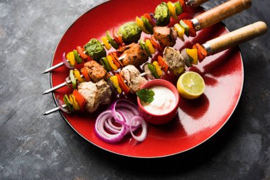 Hariyali kakab tavuk mu ile hizmet Malai malai Kebap şişleri ve yoğurt dip bir tabak içinde. seçici odak