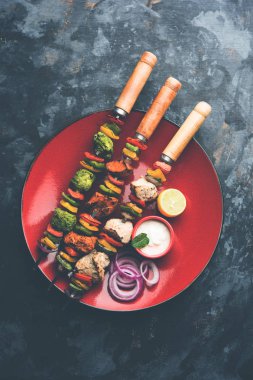 Hariyali kakab tavuk mu ile hizmet Malai malai Kebap şişleri ve yoğurt dip bir tabak içinde. seçici odak