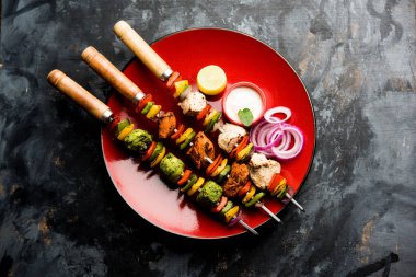 Hariyali kakab tavuk mu ile hizmet Malai malai Kebap şişleri ve yoğurt dip bir tabak içinde. seçici odak