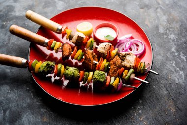 Hariyali kakab tavuk mu ile hizmet Malai malai Kebap şişleri ve yoğurt dip bir tabak içinde. seçici odak