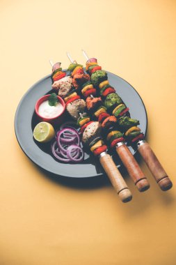 Hariyali kakab tavuk mu ile hizmet Malai malai Kebap şişleri ve yoğurt dip bir tabak içinde. seçici odak