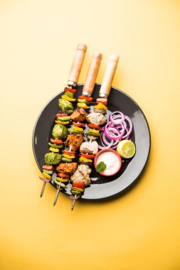 Hariyali kakab tavuk mu ile hizmet Malai malai Kebap şişleri ve yoğurt dip bir tabak içinde. seçici odak