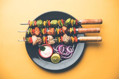 Hariyali kakab tavuk mu ile hizmet Malai malai Kebap şişleri ve yoğurt dip bir tabak içinde. seçici odak