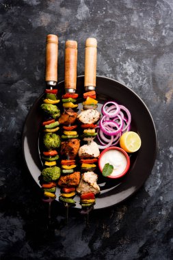 Hariyali kakab tavuk mu ile hizmet Malai malai Kebap şişleri ve yoğurt dip bir tabak içinde. seçici odak