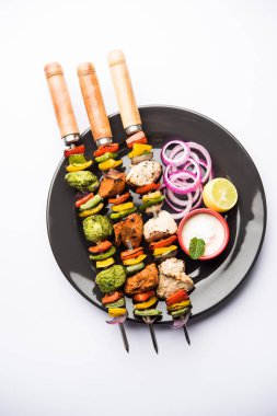 Hariyali kakab tavuk mu ile hizmet Malai malai Kebap şişleri ve yoğurt dip bir tabak içinde. seçici odak