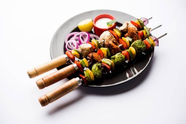 Hariyali kakab tavuk mu ile hizmet Malai malai Kebap şişleri ve yoğurt dip bir tabak içinde. seçici odak