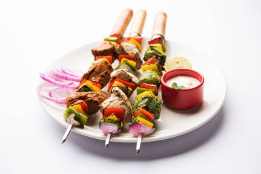 Hariyali kakab tavuk mu ile hizmet Malai malai Kebap şişleri ve yoğurt dip bir tabak içinde. seçici odak