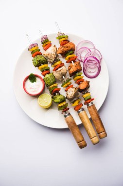 Hariyali kakab tavuk mu ile hizmet Malai malai Kebap şişleri ve yoğurt dip bir tabak içinde. seçici odak