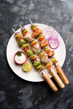 Hariyali kakab tavuk mu ile hizmet Malai malai Kebap şişleri ve yoğurt dip bir tabak içinde. seçici odak