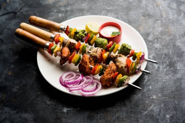 Hariyali kakab tavuk mu ile hizmet Malai malai Kebap şişleri ve yoğurt dip bir tabak içinde. seçici odak