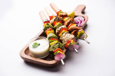 Hariyali kakab tavuk mu ile hizmet Malai malai Kebap şişleri ve yoğurt dip bir tabak içinde. seçici odak