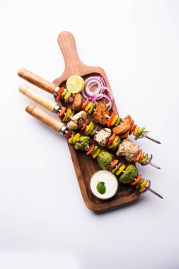 Hariyali kakab tavuk mu ile hizmet Malai malai Kebap şişleri ve yoğurt dip bir tabak içinde. seçici odak