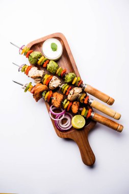 Hariyali kakab tavuk mu ile hizmet Malai malai Kebap şişleri ve yoğurt dip bir tabak içinde. seçici odak