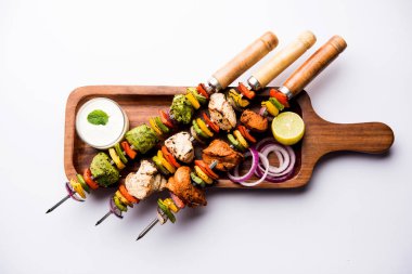 Hariyali kakab tavuk mu ile hizmet Malai malai Kebap şişleri ve yoğurt dip bir tabak içinde. seçici odak