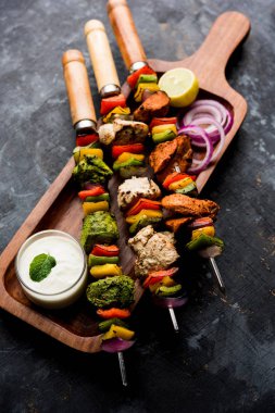 Hariyali kakab tavuk mu ile hizmet Malai malai Kebap şişleri ve yoğurt dip bir tabak içinde. seçici odak