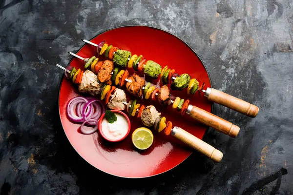 Hariyali kakab tavuk mu ile hizmet Malai malai Kebap şişleri ve yoğurt dip bir tabak içinde. seçici odak