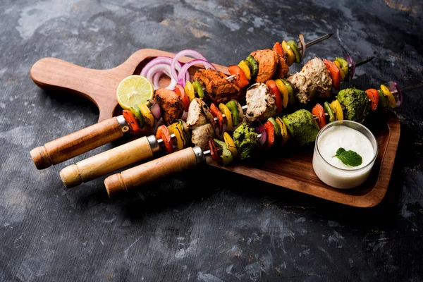 Hariyali kakab tavuk mu ile hizmet Malai malai Kebap şişleri ve yoğurt dip bir tabak içinde. seçici odak