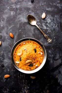 Badaam kesar shira / Sheera or almond saffron halwa, popular Indian dessert served in a bowl. selective focus clipart