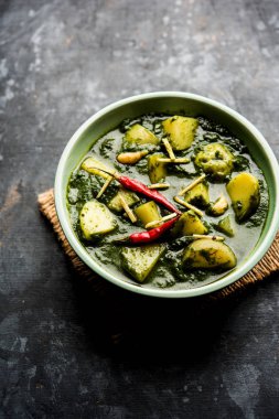 Aloo Palak Sabzi ya da bir kasede servis edilen ıspanaklı patates körisi. Popüler Hint sağlıklı tarifi. Seçici odak