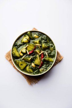 Aloo Palak Sabzi ya da bir kasede servis edilen ıspanaklı patates körisi. Popüler Hint sağlıklı tarifi. Seçici odak