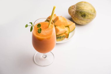 Misk kavun suyu ile dilim, olarak da bilinen Kharbuj/kharbuja meyve özü, bir bardak nane ile servis. seçici odak