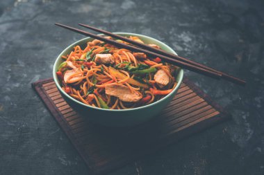 Tavuk Hakka / Schezwan erişte yemek çubukları ile bir kase içinde servis edilir. seçici odaklama