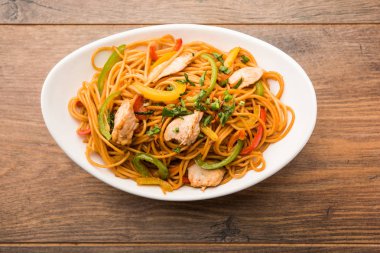 Tavuk Hakka / Schezwan erişte yemek çubukları ile bir kase içinde servis edilir. seçici odaklama