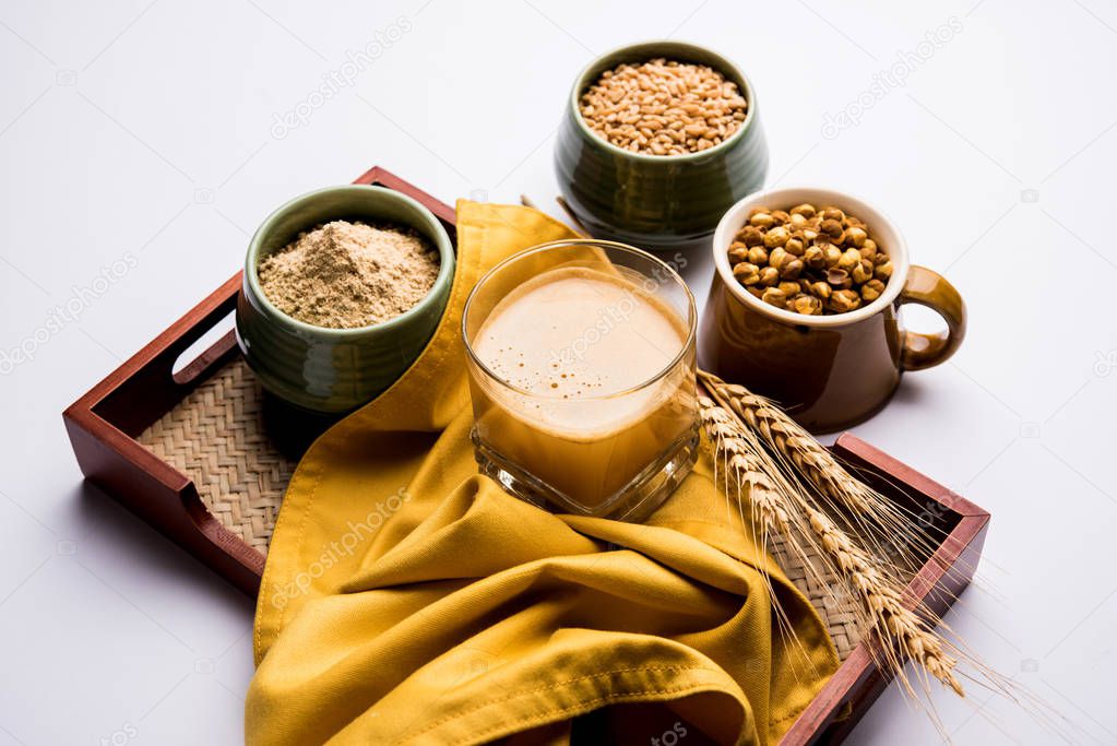 Sattu sharbat is a cooling sweet drink made in summer with roasted black chickpea flour, barley, suger, salt & water. served in a glass. selective focus