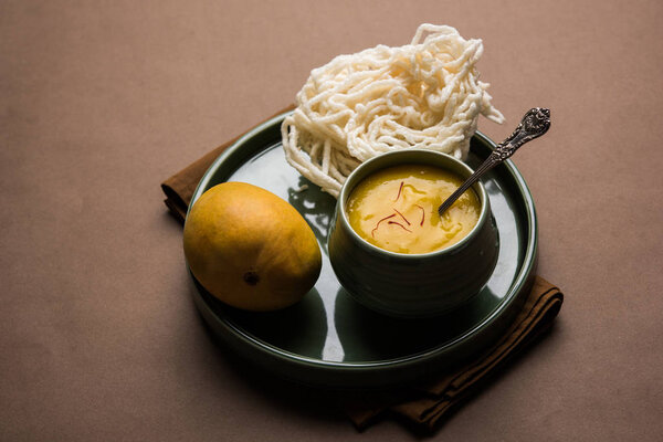 Aam Ras or Alphonso mango pulp with kurdai which is a fried dish made using wheat/gehu. selective focus