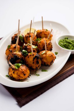 Tandır aloo Hint baharatları ile kavrulmuş patates vardır. Yeşil chutney ile servis edilen bir parti mezesi. seçici odaklama