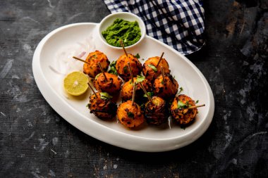 Tandır aloo Hint baharatları ile kavrulmuş patates vardır. Yeşil chutney ile servis edilen bir parti mezesi. seçici odaklama