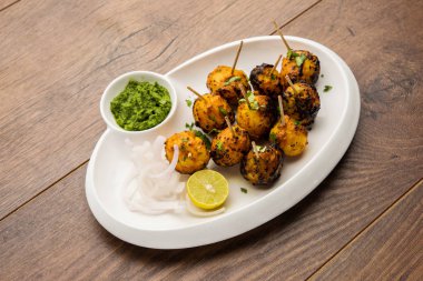 Tandır aloo Hint baharatları ile kavrulmuş patates vardır. Yeşil chutney ile servis edilen bir parti mezesi. seçici odaklama