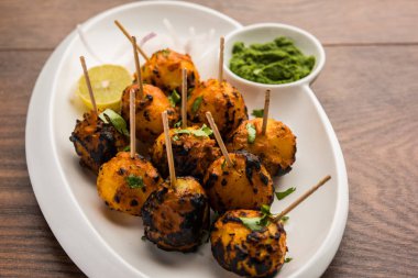 Tandır aloo Hint baharatları ile kavrulmuş patates vardır. Yeşil chutney ile servis edilen bir parti mezesi. seçici odaklama