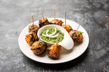 Tandır aloo Hint baharatları ile kavrulmuş patates vardır. Yeşil chutney ile servis edilen bir parti mezesi. seçici odaklama