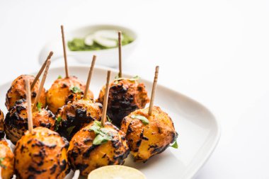 Tandır aloo Hint baharatları ile kavrulmuş patates vardır. Yeşil chutney ile servis edilen bir parti mezesi. seçici odaklama