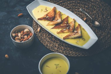 shahi tukra/tukda veya Double ka meetha kuru meyve, seçici odak ile süslenmiş kuduz veya tatlı safran süt batırılmış kızarmış ekmek dilimleri hint tatlı bir ekmek puding