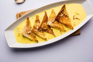 shahi tukra/tukda veya Double ka meetha kuru meyve, seçici odak ile süslenmiş kuduz veya tatlı safran süt batırılmış kızarmış ekmek dilimleri hint tatlı bir ekmek puding