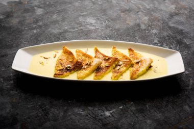 shahi tukra/tukda veya Double ka meetha kuru meyve, seçici odak ile süslenmiş kuduz veya tatlı safran süt batırılmış kızarmış ekmek dilimleri hint tatlı bir ekmek puding