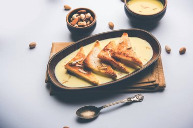 shahi tukra/tukda veya Double ka meetha kuru meyve, seçici odak ile süslenmiş kuduz veya tatlı safran süt batırılmış kızarmış ekmek dilimleri hint tatlı bir ekmek puding