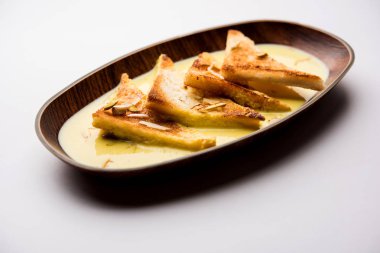 shahi tukra/tukda veya Double ka meetha kuru meyve, seçici odak ile süslenmiş kuduz veya tatlı safran süt batırılmış kızarmış ekmek dilimleri hint tatlı bir ekmek puding