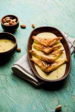 shahi tukra/tukda veya Double ka meetha kuru meyve, seçici odak ile süslenmiş kuduz veya tatlı safran süt batırılmış kızarmış ekmek dilimleri hint tatlı bir ekmek puding