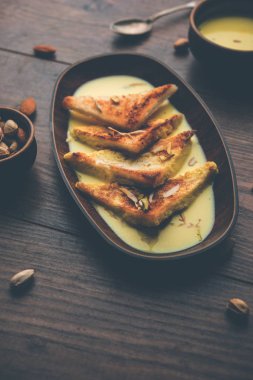 shahi tukra/tukda veya Double ka meetha kuru meyve, seçici odak ile süslenmiş kuduz veya tatlı safran süt batırılmış kızarmış ekmek dilimleri hint tatlı bir ekmek puding