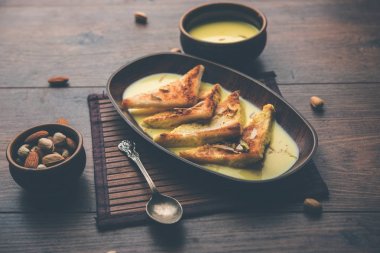 shahi tukra/tukda veya Double ka meetha kuru meyve, seçici odak ile süslenmiş kuduz veya tatlı safran süt batırılmış kızarmış ekmek dilimleri hint tatlı bir ekmek puding