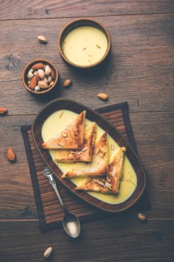 shahi tukra/tukda veya Double ka meetha kuru meyve, seçici odak ile süslenmiş kuduz veya tatlı safran süt batırılmış kızarmış ekmek dilimleri hint tatlı bir ekmek puding