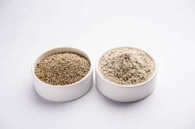 Bajra (inci darı)/bir kasede onun un veya tozu ile sorgum taneleri, seçici odak