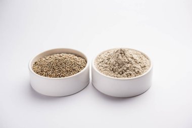 Bajra (inci darı)/bir kasede onun un veya tozu ile sorgum taneleri, seçici odak