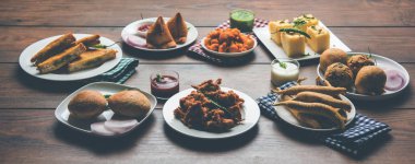 Grup Hint Çay saati aperatifler Veg Samosa, Kachori / kachaudi, aloo bonda, khaman dhokla, ekmek, soğan, biber ve moong pakora / pakoda / bhaji / bhajji / Bhajiya / soslar, seçici odak ile bajji içerir