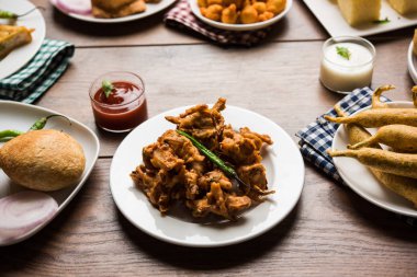 Grup Hint Çay saati aperatifler Veg Samosa, Kachori / kachaudi, aloo bonda, khaman dhokla, ekmek, soğan, biber ve moong pakora / pakoda / bhaji / bhajji / Bhajiya / soslar, seçici odak ile bajji içerir