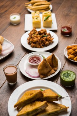 Grup Hint Çay saati aperatifler Veg Samosa, Kachori / kachaudi, aloo bonda, khaman dhokla, ekmek, soğan, biber ve moong pakora / pakoda / bhaji / bhajji / Bhajiya / soslar, seçici odak ile bajji içerir