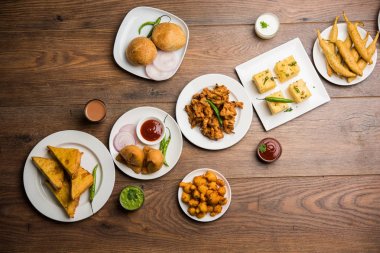 Grup Hint Çay saati aperatifler Veg Samosa, Kachori / kachaudi, aloo bonda, khaman dhokla, ekmek, soğan, biber ve moong pakora / pakoda / bhaji / bhajji / Bhajiya / soslar, seçici odak ile bajji içerir